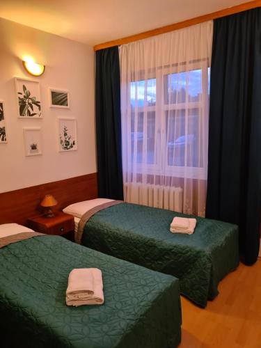 Habitación de hotel con 2 camas y ventana en Pokoje gościnne Restauracji Don Roberto, en Frombork
