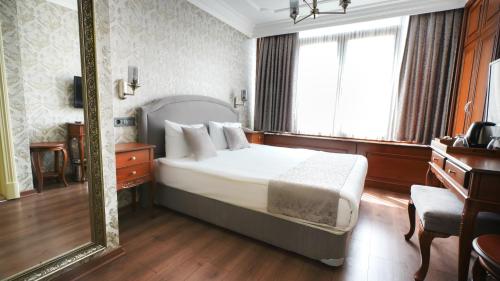 um quarto com uma cama grande e um espelho em Hotel Gritti Pera & Spa em Istambul