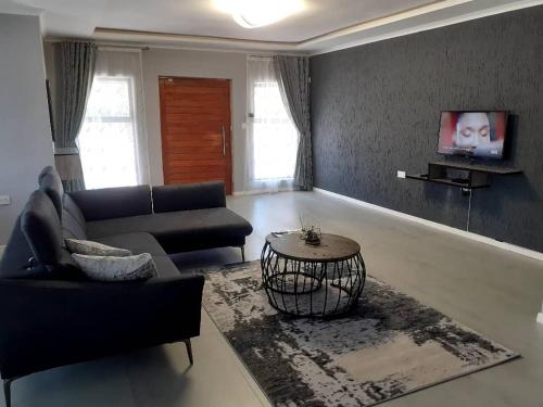 a living room with a couch and a table at Villa 13 Maun in Maun