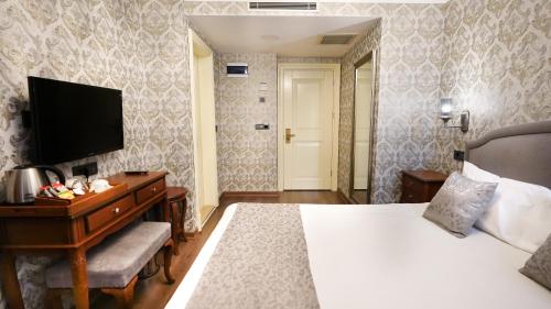 a hotel room with a bed and a television at Hotel Gritti Pera & Spa in Istanbul