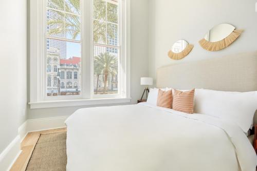 a white bedroom with a large bed and a window at Sonder at The Vitascope in New Orleans