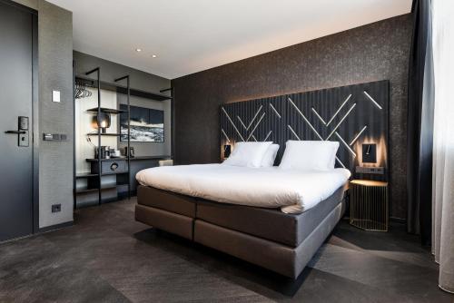 a bedroom with a large bed with a black wall at Le Marin Boutique Hotel in Rotterdam