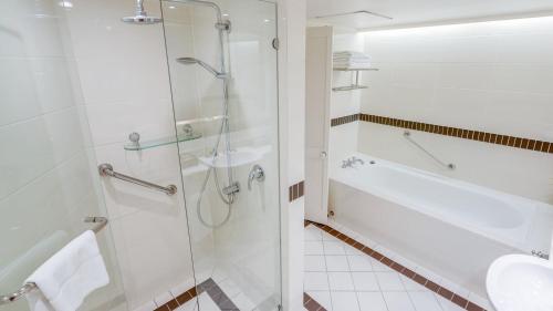 a bathroom with a shower and a sink at InterContinental Sanctuary Cove Resort by IHG in Gold Coast