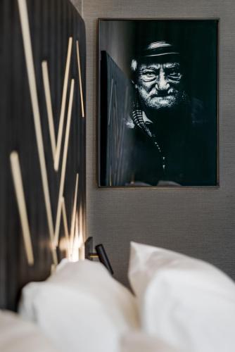 a picture of a man in a hat on a wall at Le Marin Hotel Rotterdam City - Handwritten Collection in Rotterdam