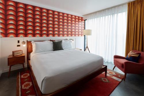 a bedroom with a large bed and a red wall at RISE Uptown in Phoenix