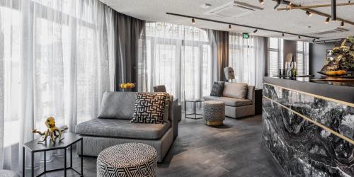 a living room with a couch and a chair at Le Marin Hotel Rotterdam City - Handwritten Collection in Rotterdam