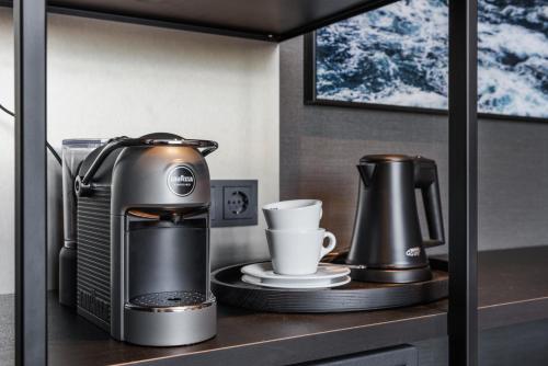 a coffee maker and a cup on a shelf at Le Marin Hotel Rotterdam City - Handwritten Collection in Rotterdam
