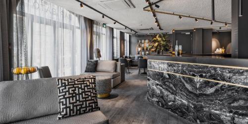 a lobby with a couch and chairs and a bar at Le Marin Hotel Rotterdam City - Handwritten Collection in Rotterdam