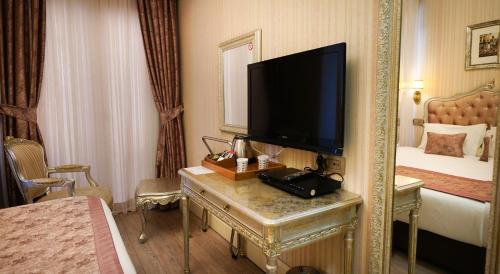a hotel room with a television and a bed at Hotel Gritti Pera & Spa in Istanbul
