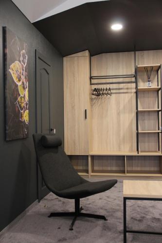 una silla negra en una habitación con armarios de madera en Senoji užeiga, en Molėtai