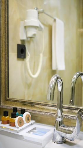 a bathroom sink with a mirror and a toothbrush at Hotel Gritti Pera & Spa in Istanbul
