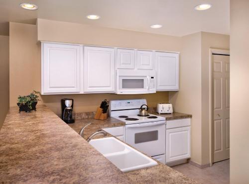 a kitchen with white cabinets and a stove and a sink at WorldMark Branson in Branson