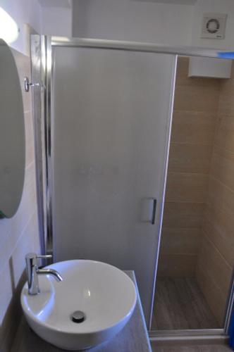 a bathroom with a white sink and a shower at Coral Front Beach in Káto Zákros