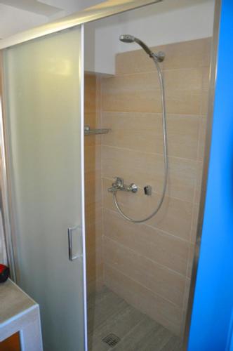 a shower with a glass door in a bathroom at Coral Front Beach in Káto Zákros