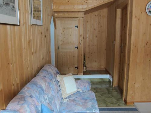 a living room with a couch in a room with wooden walls at Fuldera Daint chasa Zanoli Wohnung Parterre in Fuldera