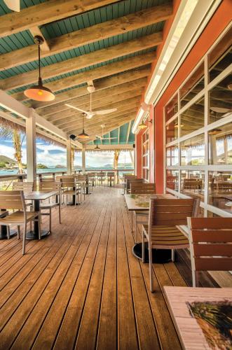 a restaurant with wooden tables and benches on a deck at Margaritaville Vacation Club - St Thomas in Frydendal