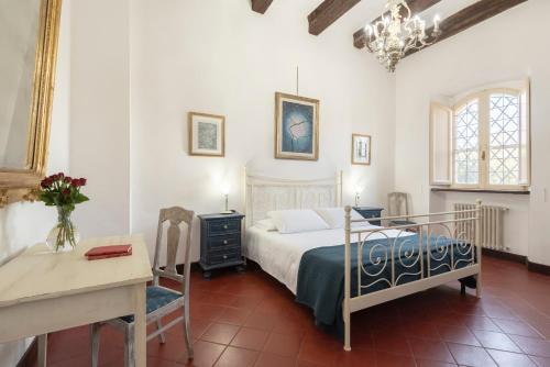 a bedroom with a bed and a table and a desk at Fattoria Pian Di Rocca in Castiglione della Pescaia
