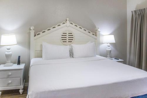 a bedroom with a white bed with two lamps at Bryan's Spanish Cove in Orlando