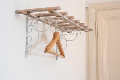 a hanging coat rack with a wooden initial on a wall at Fattoria Pian Di Rocca in Castiglione della Pescaia
