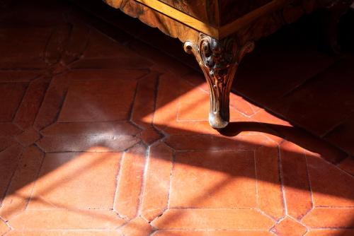 a wooden table is casting a shadow on the floor at Fattoria Pian Di Rocca in Castiglione della Pescaia