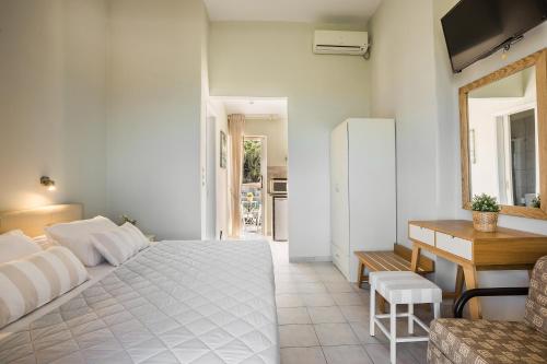 a bedroom with a bed and a table and a desk at Panorama Fanari studios and apartments in Argostoli