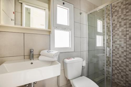 a bathroom with a toilet and a sink and a shower at Panorama Fanari studios and apartments in Argostoli