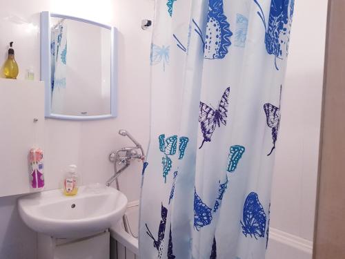 une salle de bain avec un lavabo et un rideau de douche dans l'établissement Apartment on Zoe Kosmodemyanskoy, à Pinsk