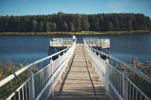 a wooden bridge over a body of water at Senoji užeiga in Molėtai