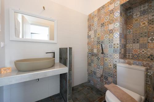 a bathroom with a sink and a toilet and a mirror at Mosxa House in Artemonas