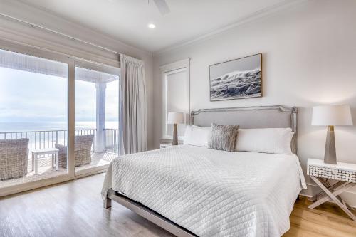 a white bedroom with a bed and a balcony at Beach Vista Two in Orange Beach