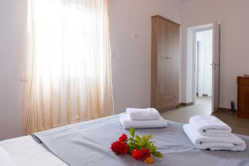 une chambre avec un lit recouvert de serviettes et de fleurs dans l'établissement Mosxa House, à Artemonas