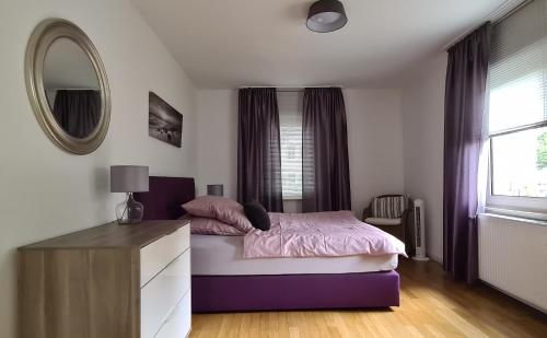 ミュルハイム・アン・デア・ルールにあるGästehaus Mülheimのベッドルーム(紫色のベッド1台、鏡付)