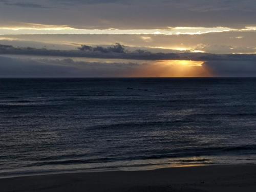 a sunset on the beach with the ocean at On The Beach At Strand in Strand