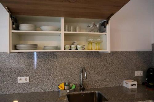 - un comptoir de cuisine avec des placards blancs et un évier dans l'établissement Apartamento CATA Santiago de Compostela, à Saint-Jacques-de-Compostelle