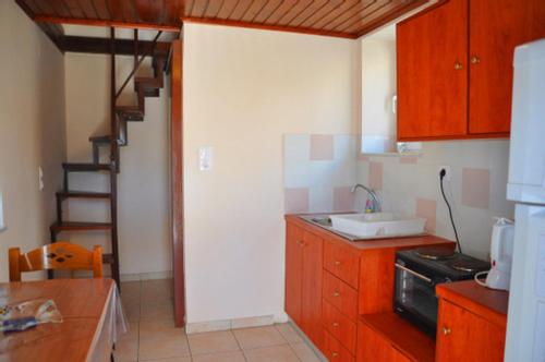 une cuisine avec un évier et un escalier. dans l'établissement Tania village Zakros maisonette, à Zakros