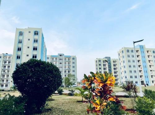 a group of tall white buildings in a park at Apex Mbweni Apartment in Kiembi Samaki