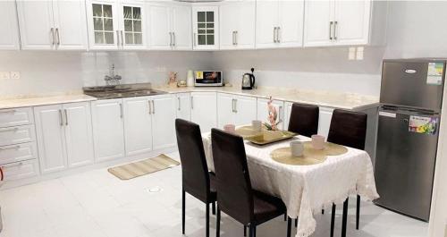 eine Küche mit einem Tisch mit Stühlen und einem Kühlschrank in der Unterkunft مساكن الدار 1 in Abha