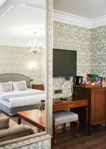 a bedroom with a bed and a desk with a mirror at Hotel Gritti Pera & Spa in Istanbul