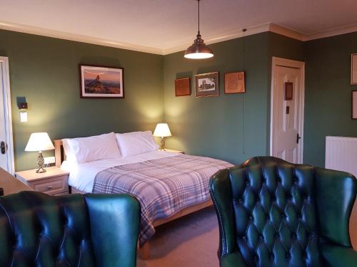 a bedroom with a bed and two chairs at Afallon Townhouse Salop Room in Dolgellau