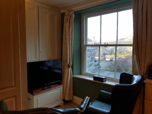 a living room with a large window and a television at Afallon Townhouse Salop Room in Dolgellau