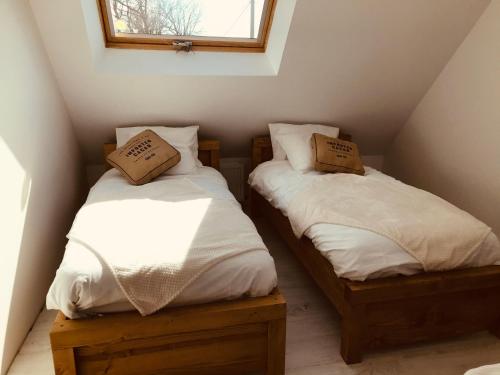 deux lits jumeaux dans une chambre avec fenêtre dans l'établissement Maison entre terre et mer proche Etretat, à Saint-Jouin-Bruneval