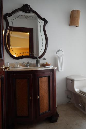 a bathroom with a sink and a mirror on the wall at Hotel Boutique Villa Casuarinas in Cali