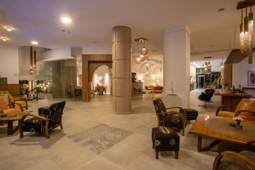 a lobby with tables and chairs in a building at Dellarosa Boutique Hotel and Spa in Marrakech