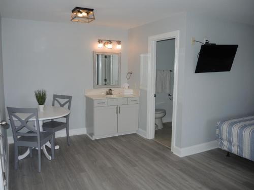 a bathroom with a table and a sink and a bathroom with a bed at 1408L home in Calabash