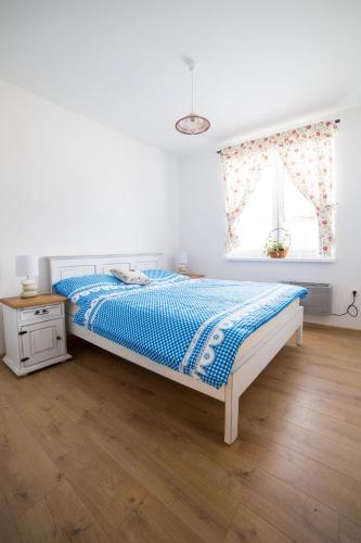 a white bedroom with a bed and a window at Domčeky Sabinka a Melinka in Valča