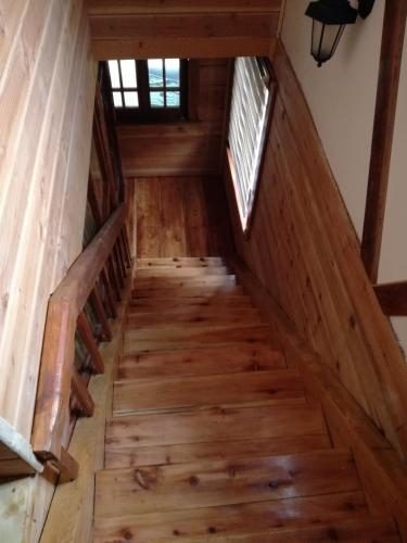 a staircase in a cabin with wooden floors and a window at Brvnara Aleksic in Kraljevo