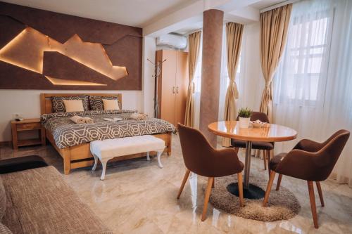 um quarto com uma cama, uma mesa e cadeiras em Villa Fortuna em Ohrid