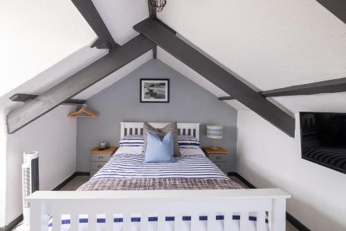 a bedroom with a white bed with blue pillows at Central Penzance, Modern stylish home, Near Seafront with Gated parking in Penzance