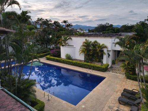 a swimming pool in the backyard of a house with palm trees at Hotel Boutique Villa Casuarinas in Cali