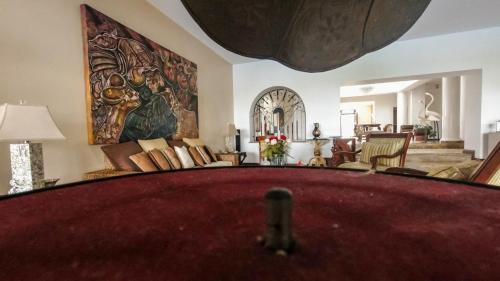 a living room with a pool table in the foreground at Hotel Boutique Villa Casuarinas in Cali
